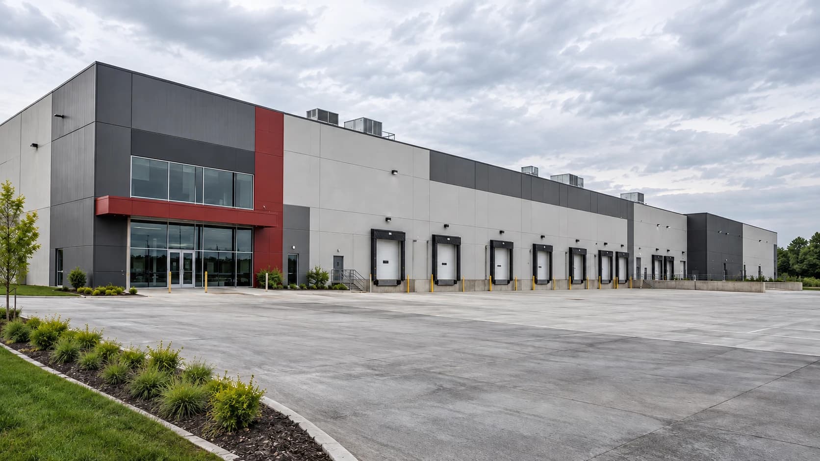 Illustrative distribution warehouse with loading docks, rooftop units and restrained crimson facade accents