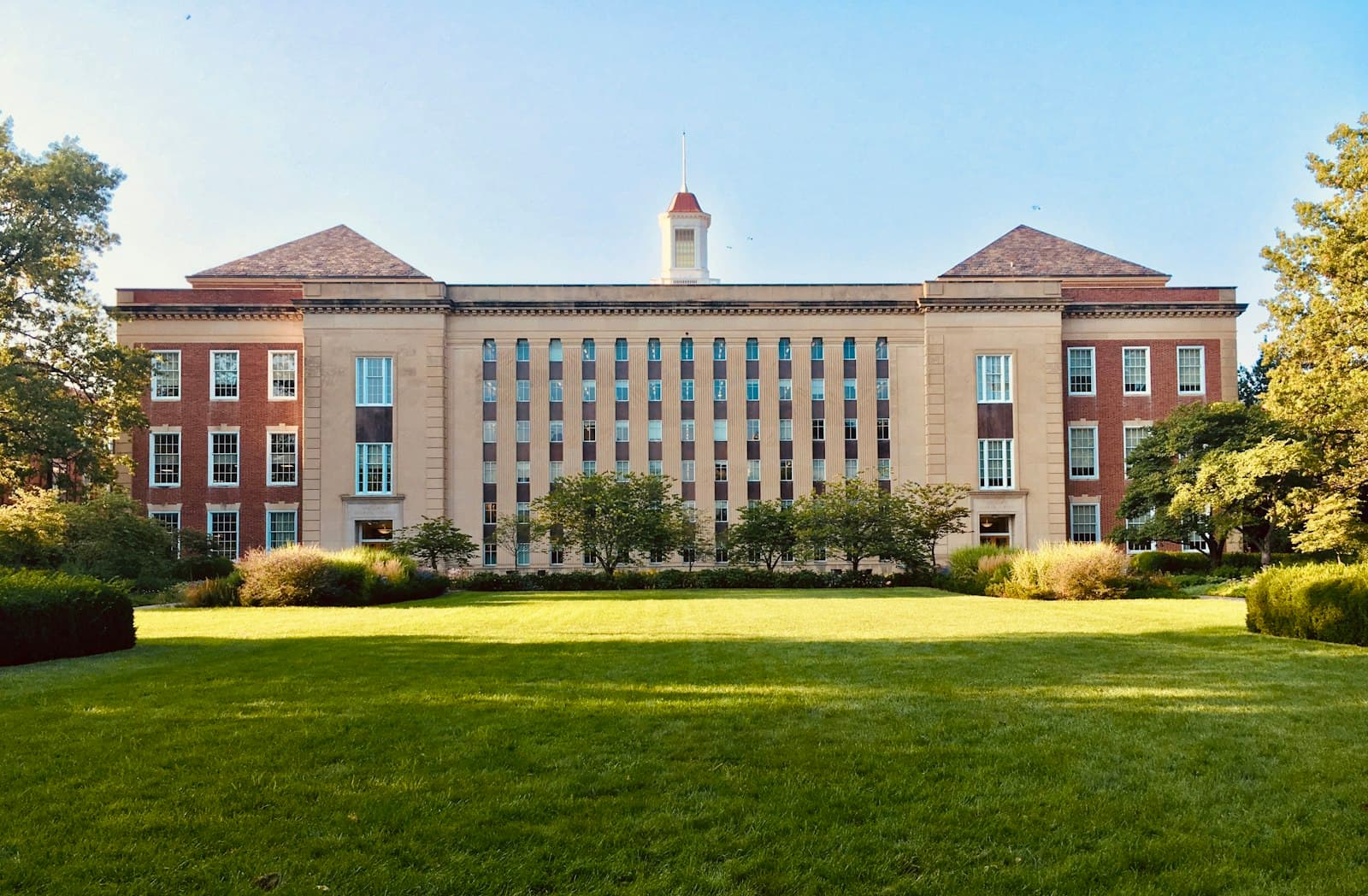 Brick campus academic building across a lawn