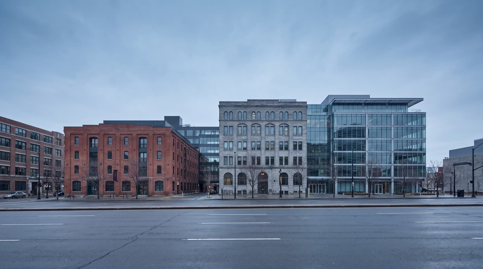 Row of varied commercial buildings, brick, stone, and glass, along a downtown street